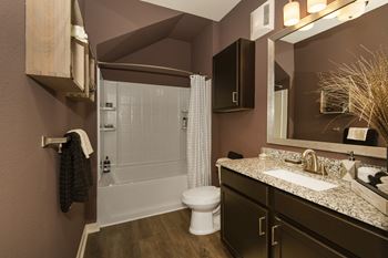 A bathroom with a shower toilet and sink and a mirror